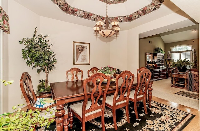 dining room featuring a chandelier, wood-type flooring, and a tray ceiling