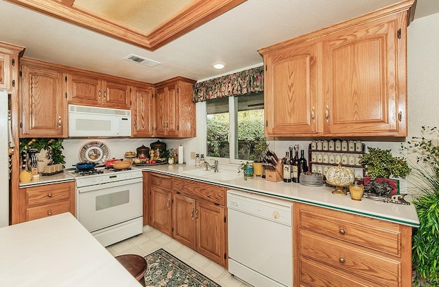 kitchen with sink, crown molding, a textured ceiling, and white appliances