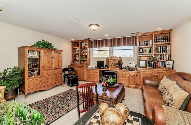 carpeted office space featuring built in desk