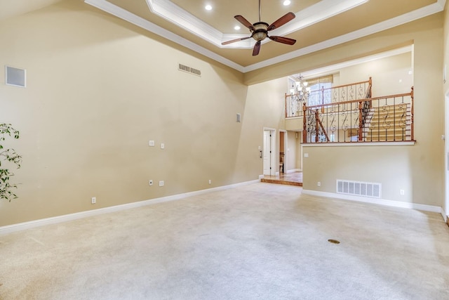 unfurnished living room featuring crown molding, ceiling fan with notable chandelier, a high ceiling, and carpet