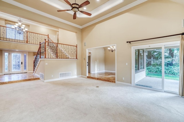 unfurnished living room with ornamental molding, a high ceiling, ceiling fan with notable chandelier, and carpet