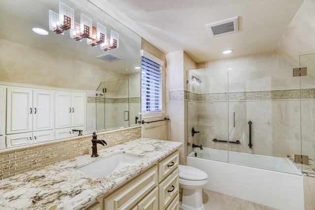 full bathroom with tasteful backsplash, toilet, bath / shower combo with glass door, vanity, and tile patterned flooring