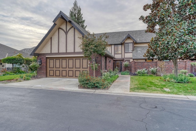 english style home with a garage and a front lawn