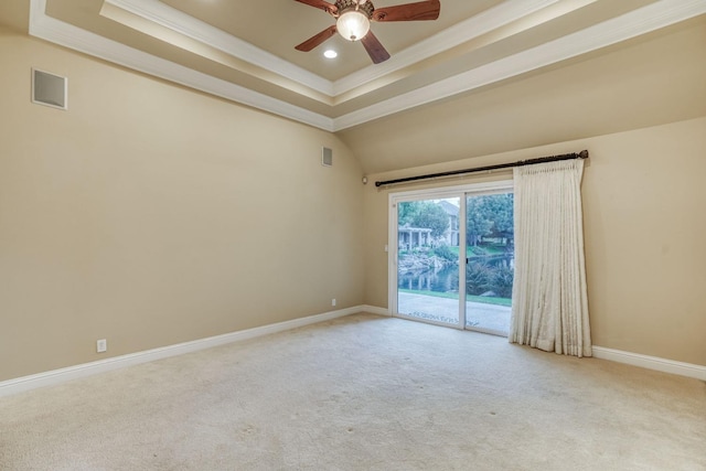 carpeted empty room featuring ceiling fan, ornamental molding, and a tray ceiling