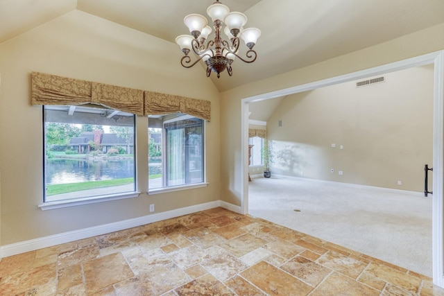 carpeted spare room with a notable chandelier and vaulted ceiling