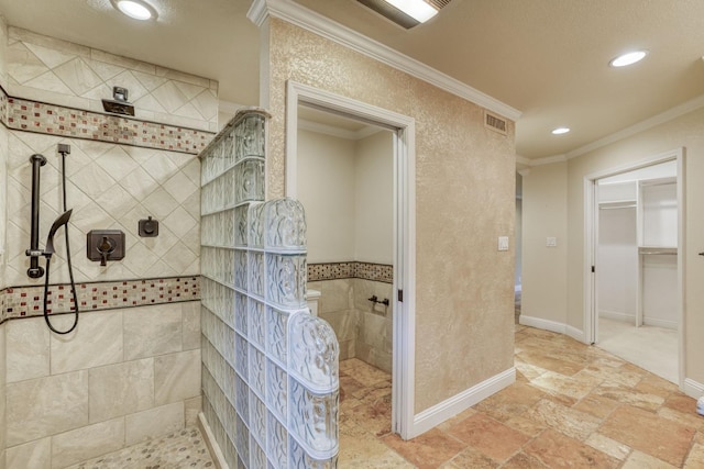 bathroom featuring ornamental molding and a tile shower