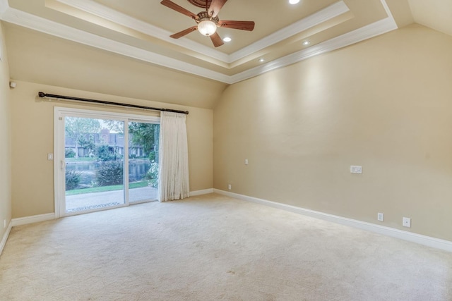 spare room with ceiling fan, ornamental molding, a tray ceiling, and light colored carpet