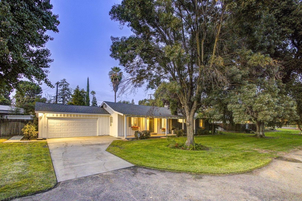 single story home with a garage and a front lawn