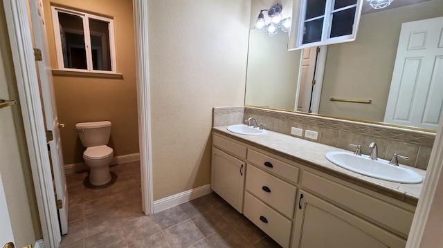 bathroom with tile patterned flooring, vanity, tasteful backsplash, and toilet