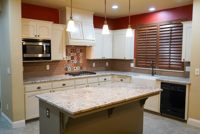 kitchen featuring stainless steel appliances, light stone countertops, hanging light fixtures, decorative backsplash, and a center island