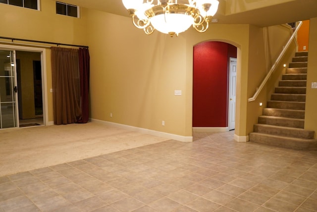 empty room with carpet flooring and an inviting chandelier