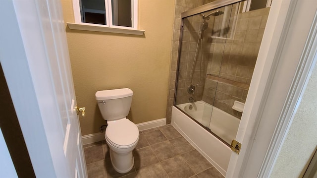 bathroom with toilet, tile patterned flooring, and shower / bath combination with glass door