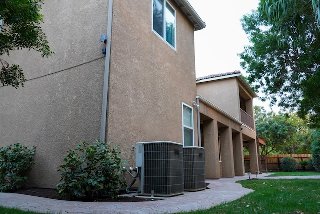 view of side of property with central AC and a balcony