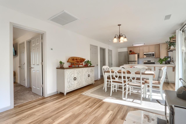 dining room featuring light hardwood / wood-style flooring and a notable chandelier