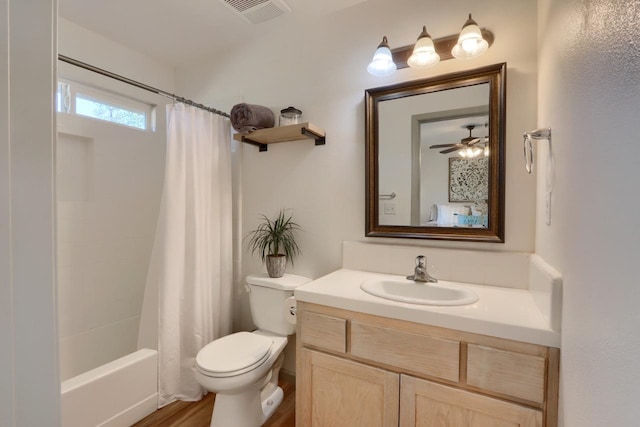 full bathroom with ceiling fan, hardwood / wood-style flooring, toilet, vanity, and shower / tub combo with curtain