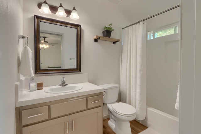 full bathroom featuring hardwood / wood-style flooring, toilet, shower / bath combination with curtain, vanity, and ceiling fan