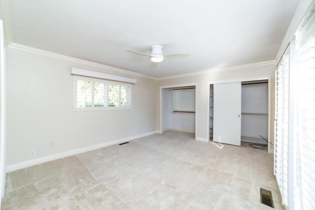 unfurnished bedroom featuring crown molding, light colored carpet, and ceiling fan