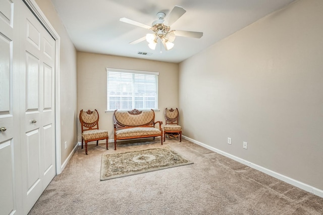 living area featuring carpet flooring and ceiling fan