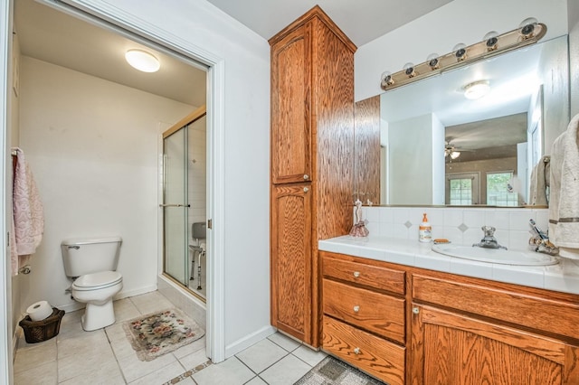 bathroom featuring backsplash, tile patterned floors, vanity, and a shower with shower door