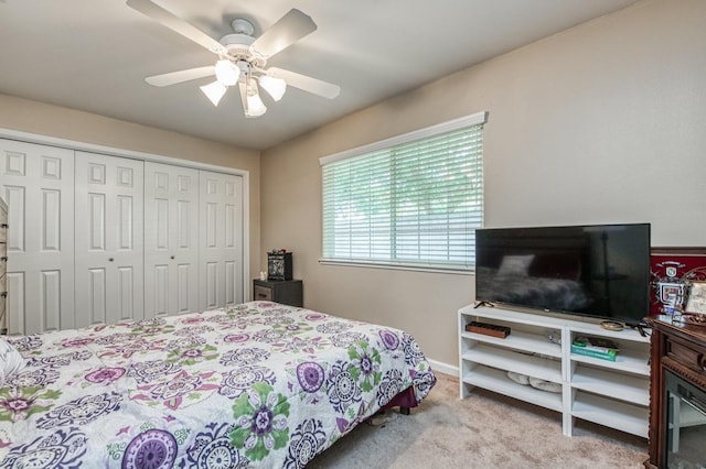 bedroom with a closet, ceiling fan, and light colored carpet