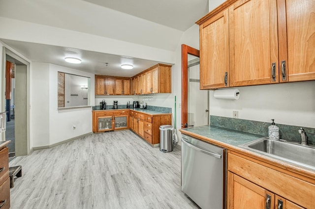 kitchen featuring stainless steel dishwasher, sink, and light hardwood / wood-style floors