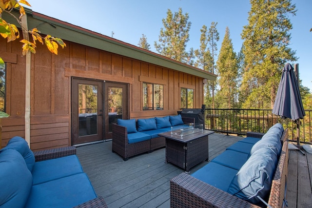 wooden terrace featuring an outdoor living space and grilling area