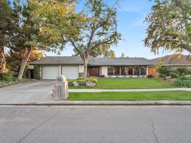 single story home with a garage and a front lawn