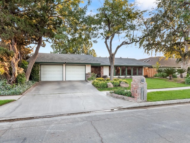 single story home featuring a garage and a front lawn