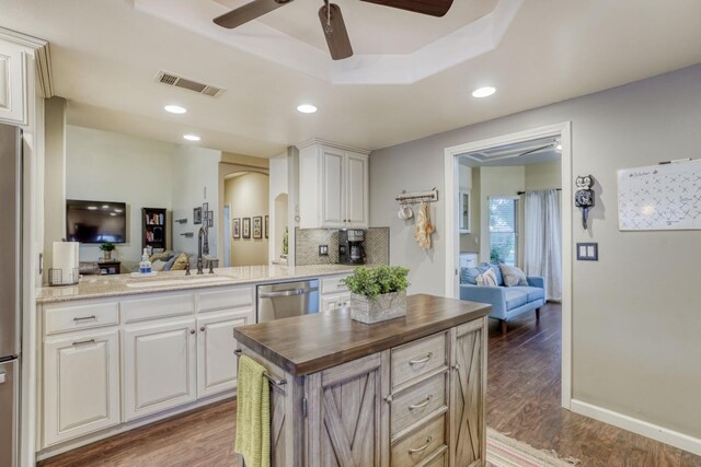 kitchen with white cabinetry, sink, kitchen peninsula, wooden counters, and dishwasher