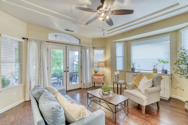 sitting room with french doors, hardwood / wood-style floors, ceiling fan, and a raised ceiling