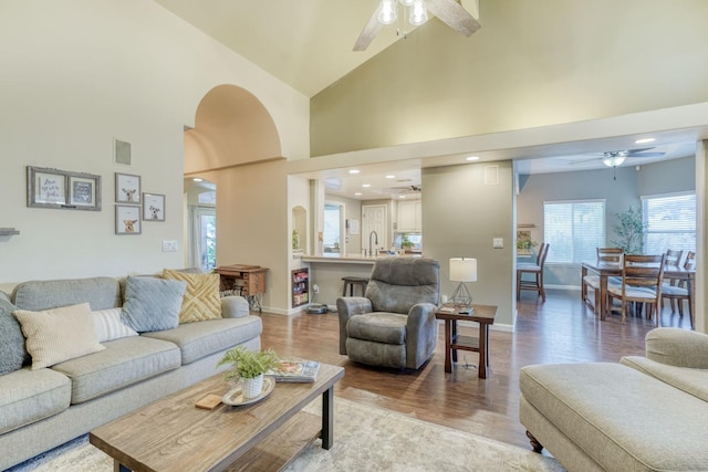 living room with high vaulted ceiling and light hardwood / wood-style flooring