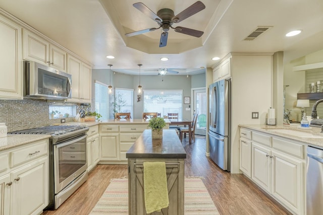 kitchen featuring cream cabinetry, sink, light hardwood / wood-style flooring, and appliances with stainless steel finishes