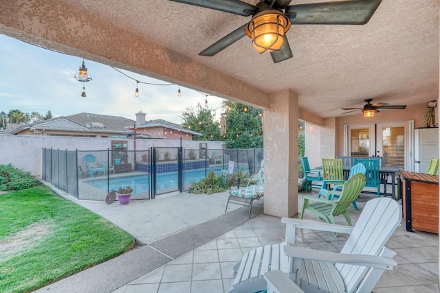 view of patio featuring french doors, ceiling fan, and a fenced in pool