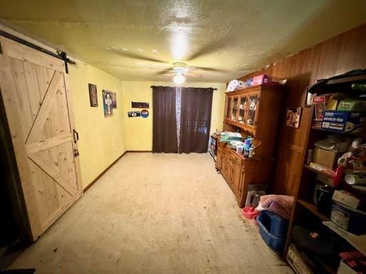 interior space featuring a barn door and ceiling fan