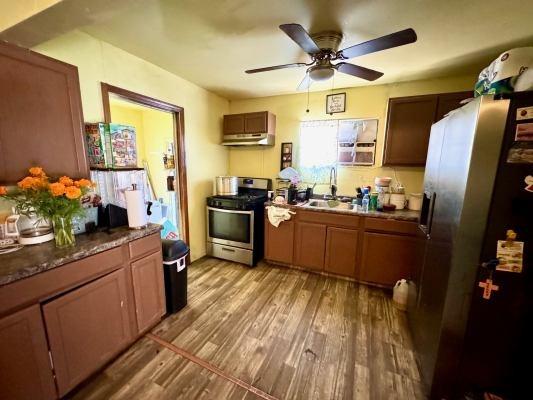 3819 E Belgravia Ave, Fresno, CA 93725 - kitchen featuring stainless steel range with gas cooktop, fridge with ice dispenser, a sink, light wood-style flooring, and a ceiling fan