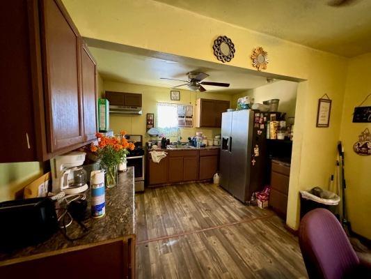 3819 E Belgravia Ave, Fresno, CA 93725 - kitchen with appliances with stainless steel finishes, ceiling fan, wood finished floors, extractor fan, and dark countertops