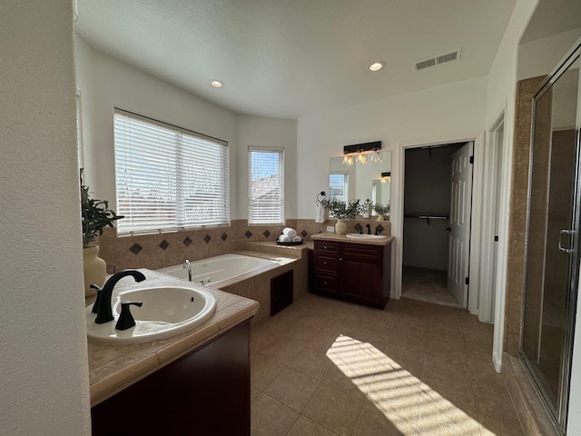 bathroom featuring tile patterned flooring, vanity, and separate shower and tub