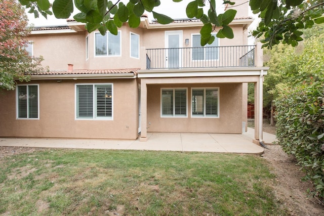 back of house featuring a yard, a patio, and a balcony