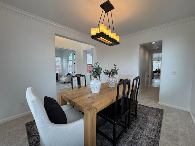 dining room featuring an inviting chandelier, crown molding, and carpet