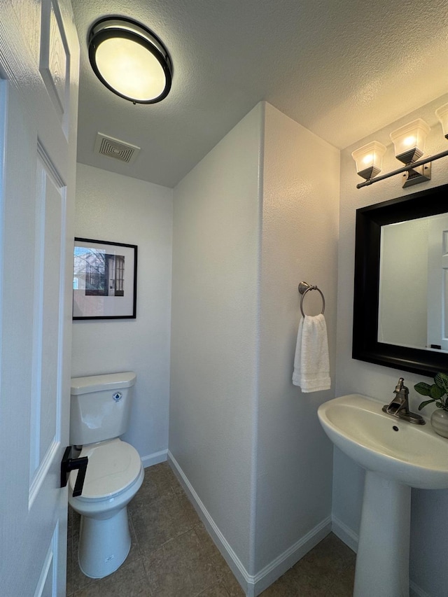 bathroom featuring toilet and a textured ceiling