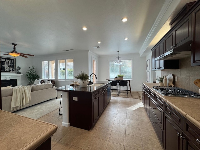 kitchen with a kitchen bar, sink, decorative light fixtures, an island with sink, and stainless steel appliances