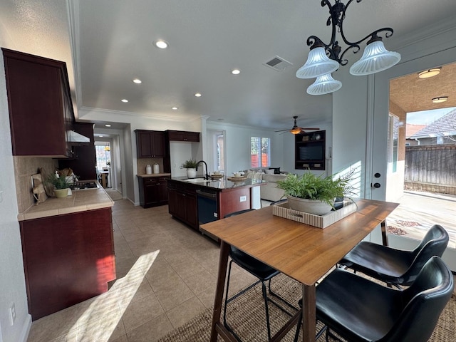 dining space with ceiling fan, ornamental molding, sink, and light tile patterned floors