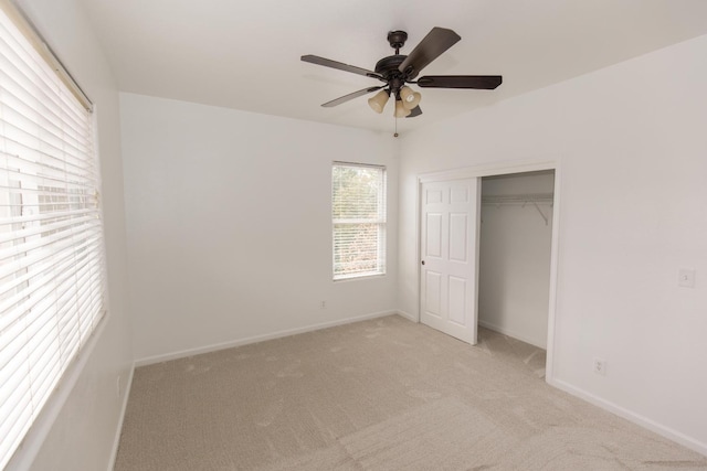 unfurnished bedroom with ceiling fan, a closet, and light carpet