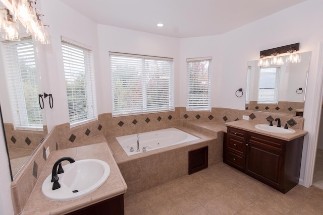 bathroom with a relaxing tiled tub, vanity, tile patterned flooring, and a wealth of natural light