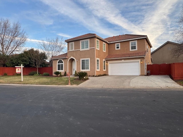 mediterranean / spanish-style house with a garage and a front yard