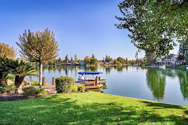 dock area with a water view and a lawn