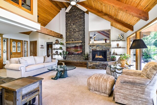 living room featuring high vaulted ceiling, carpet, ceiling fan, beamed ceiling, and a stone fireplace