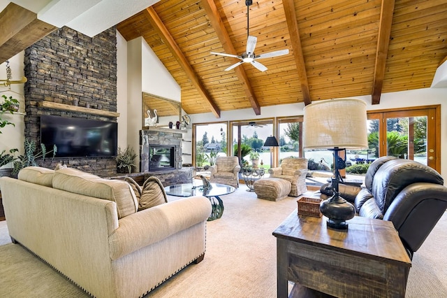 living room featuring beam ceiling, carpet, a healthy amount of sunlight, and a fireplace