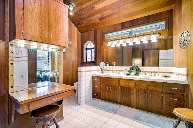 bathroom with wooden walls, wooden ceiling, lofted ceiling, tile patterned flooring, and vanity