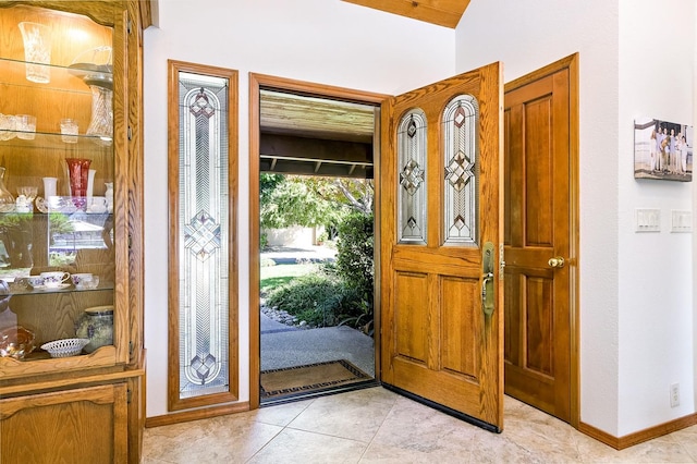 foyer entrance featuring light tile patterned floors and baseboards